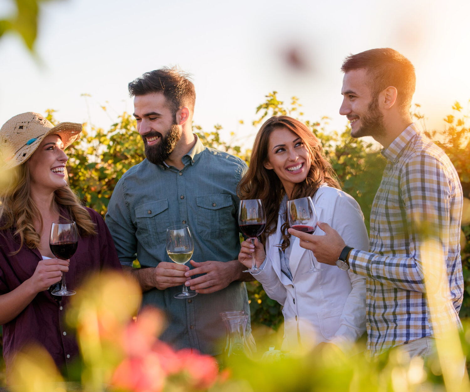 Happy friends having fun drinking wine at winery vineyard - Friendship concept with young people enjoying harvest time together